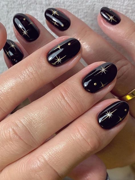 Czarny manicure ze złotym ze złotymi gwiazdkami