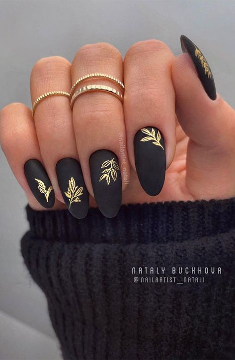 Czarny manicure ze złotymi liściami